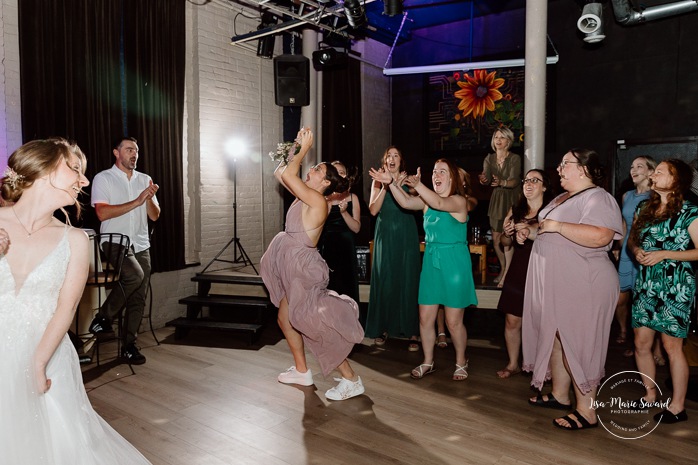 Wedding bouquet toss photos. Wedding reception in old restaurant. Mariage à l'Ambroisie à Montréal. Photographe de mariage à Montréal. Montreal wedding photographer. Photographe Petite-Bourgogne. 