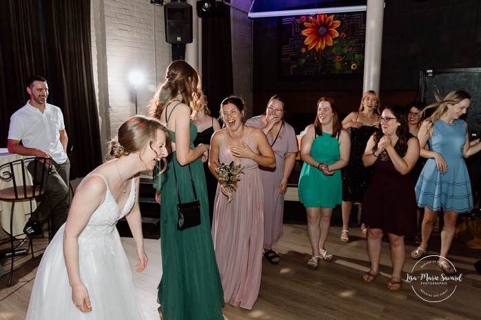 Wedding bouquet toss photos. Wedding reception in old restaurant. Mariage à l'Ambroisie à Montréal. Photographe de mariage à Montréal. Montreal wedding photographer. Photographe Petite-Bourgogne. 