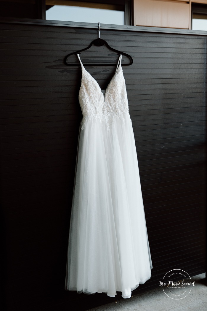 Wedding dress hanging on wall. Mariage à l'Ambroisie à Montréal. Photographe de mariage à Montréal. Montreal wedding photographer.