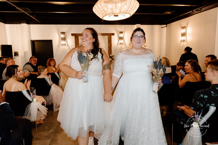 Two brides wedding. Same sex wedding. Plus size brides wedding photos. Wedding reception in small room with artificial light. Mariage avec deux femmes. Mariage LGBTQ+ au Saguenay-Lac-Saint-Jean. Photographe de mariage au Saguenay.