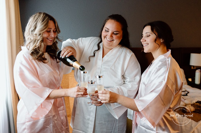 Bride getting ready in dark hotel room. Mariage avec deux femmes. Mariage LGBTQ+ au Saguenay-Lac-Saint-Jean. Photographe de mariage au Saguenay.