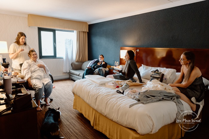 Bride getting ready in dark hotel room. Mariage avec deux femmes. Mariage LGBTQ+ au Saguenay-Lac-Saint-Jean. Photographe de mariage au Saguenay.