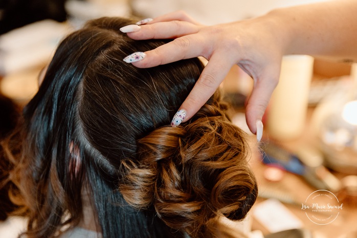 Bride getting ready in dark hotel room. Mariage avec deux femmes. Mariage LGBTQ+ au Saguenay-Lac-Saint-Jean. Photographe de mariage au Saguenay.