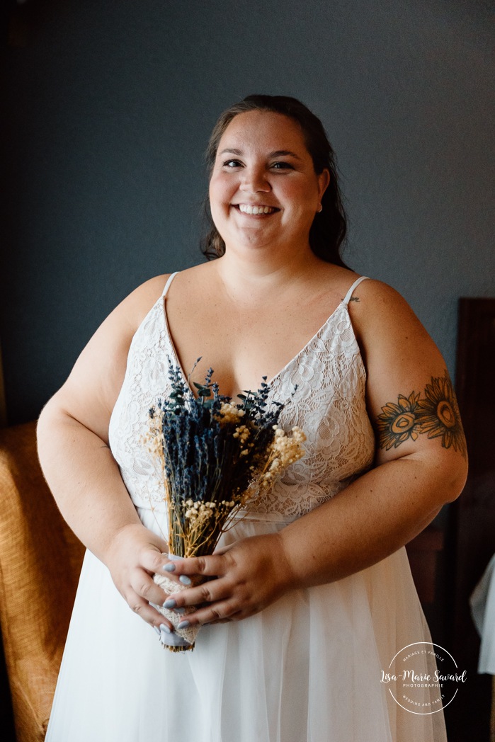 Bride getting ready in dark hotel room. Mariage avec deux femmes. Mariage LGBTQ+ au Saguenay-Lac-Saint-Jean. Photographe de mariage au Saguenay.