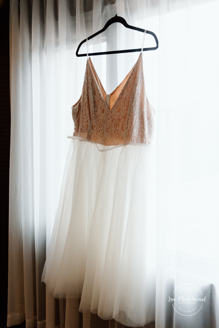 Bride getting ready in dark hotel room. Mariage avec deux femmes. Mariage LGBTQ+ au Saguenay-Lac-Saint-Jean. Photographe de mariage au Saguenay.