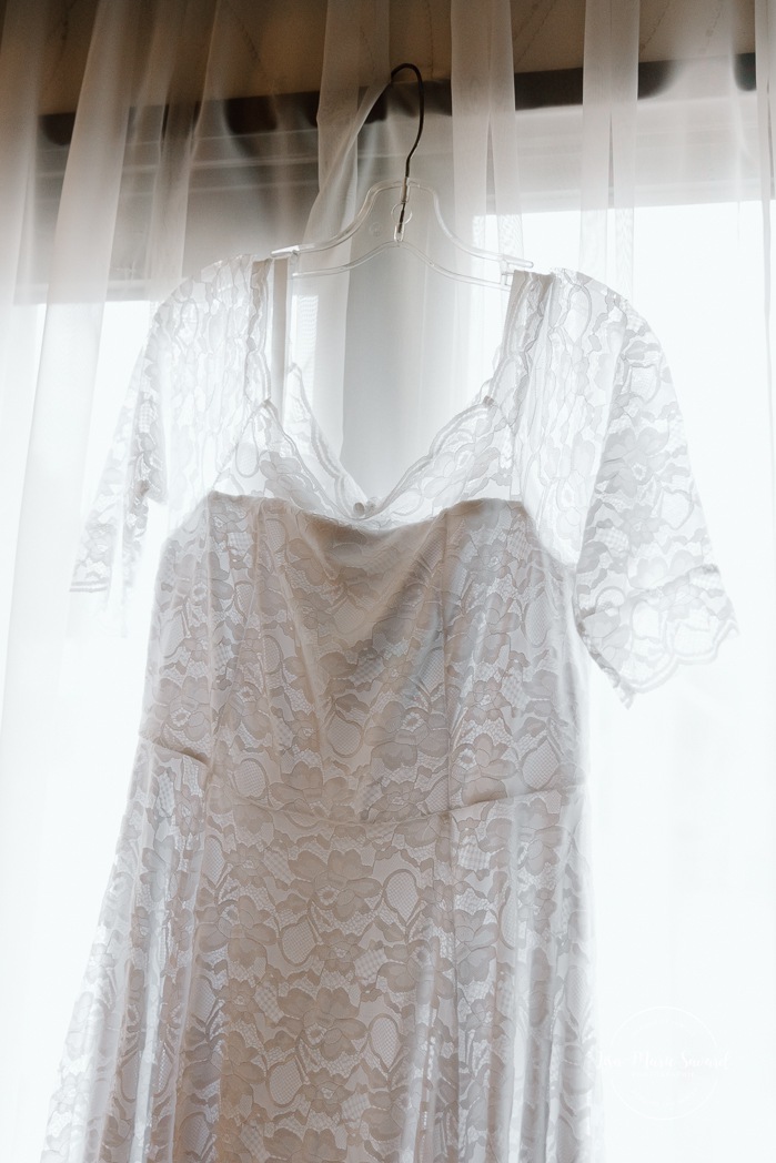 Bride getting ready in dark hotel room. Mariage avec deux femmes. Mariage LGBTQ+ au Saguenay-Lac-Saint-Jean. Photographe de mariage au Saguenay.