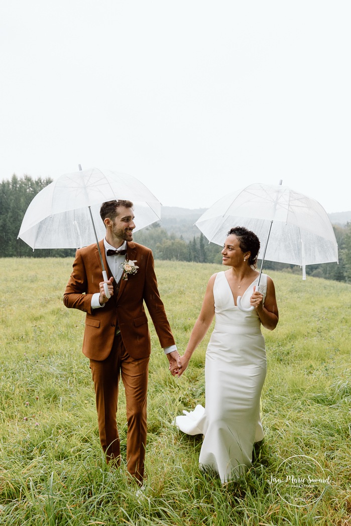 Rainy wedding photos. Wedding photos with umbrellas. Biracial wedding photos. Multicultural wedding photos. Mariage au Baluchon Éco-Villégiature. Auberge Le Baluchon. Photographe mariage Trois-Rivières.