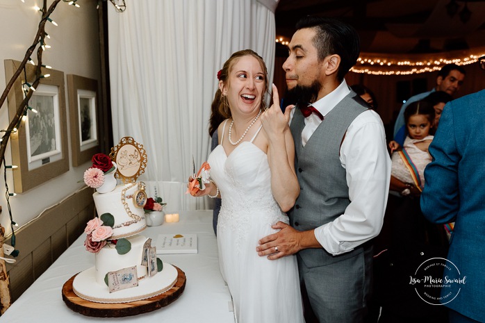 Bride and groom cutting the cake. Indoor wedding reception in sugar shack. Mariage automnal à Montréal. Montreal fall wedding photos. Mariage Cabane à Sucre Constantin. Sugar shack wedding.