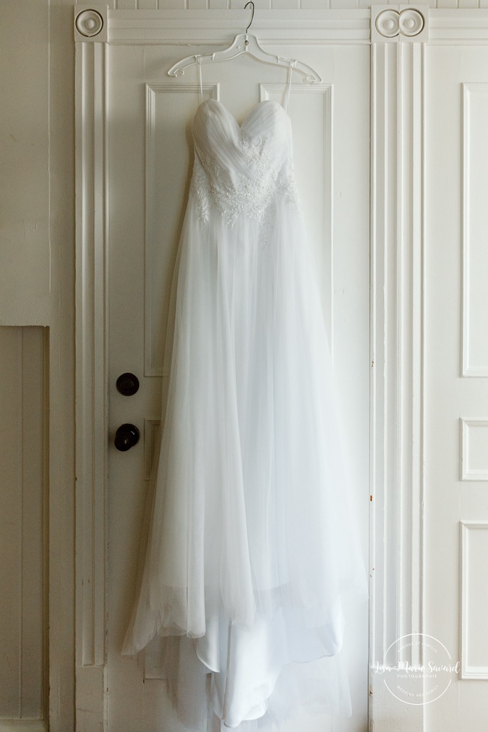 Wedding dress hanging in front of door. Mariage automnal à Montréal. Montreal fall wedding photos. Mariage Hôtel Le Rivage Maison de l'Enclos.