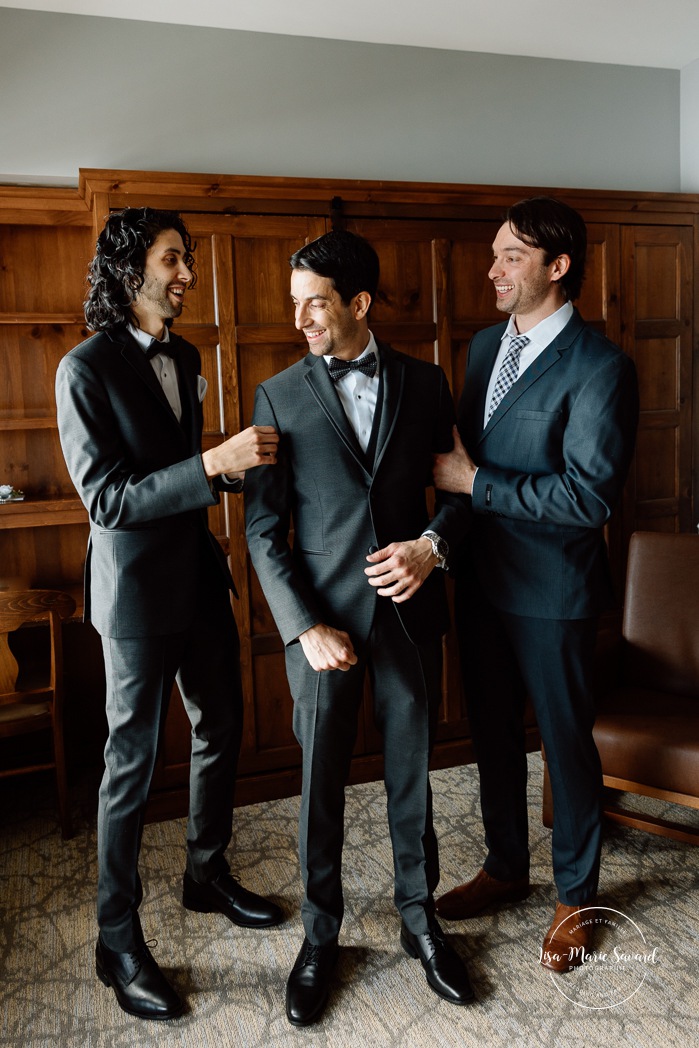 Groom getting ready with groomsmen in wooden cabin. Mariage au Grand Lodge Mont-Tremblant. Photographe de mariage à Mont-Tremblant. Grand Lodge Mont-Tremblant wedding. Mont Tremblant wedding photographer.