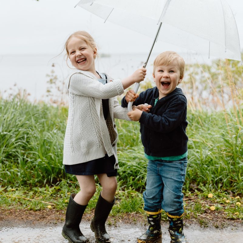 Rainy family photos. Family photos with clear umbrellas. Spring family photos. Mini séances familiales. Photos de famille pluvieuses avec parapluies. Photographe de famille à Montréal. Montreal rainy family photos.