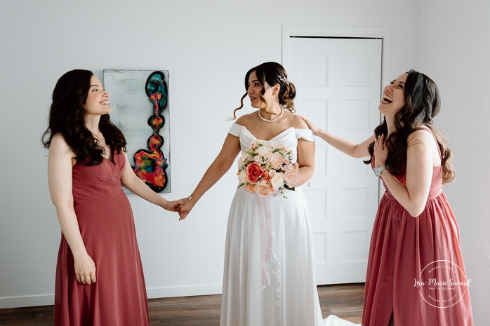 Wedding first look with bridesmaids. Bride getting ready with bridesmaids in hotel room. Mariage à l'Auberge des Îles au Lac-Saint-Jean. Photographe de mariage au Saguenay-Lac-Saint-Jean.