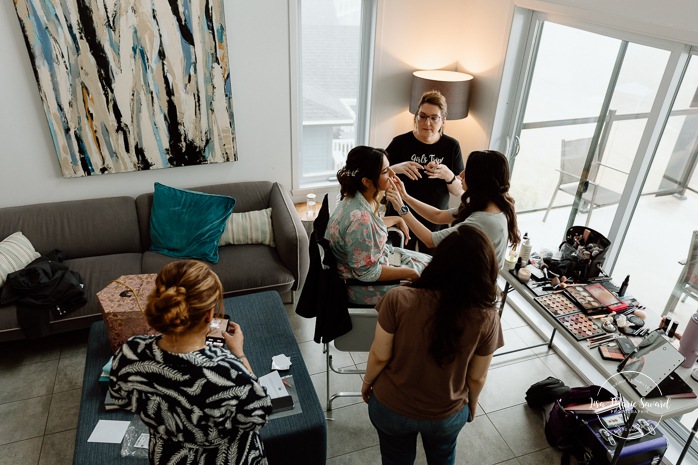 Bride getting ready with bridesmaids in hotel room. Mariage à l'Auberge des Îles au Lac-Saint-Jean. Photographe de mariage au Saguenay-Lac-Saint-Jean.