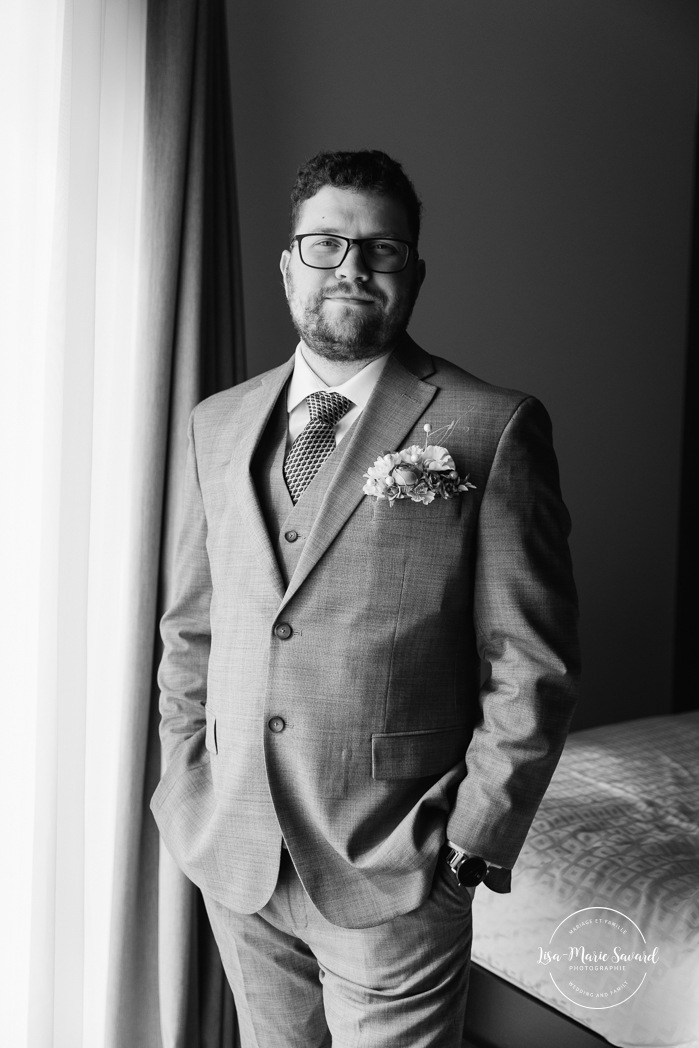 Groom getting ready with family in hotel room. Mariage à l'Auberge des Îles au Lac-Saint-Jean. Photographe de mariage au Saguenay-Lac-Saint-Jean.