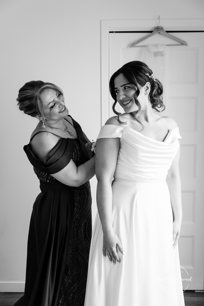 Bride getting ready with mother in hotel room. Mariage à l'Auberge des Îles au Lac-Saint-Jean. Photographe de mariage au Saguenay-Lac-Saint-Jean.