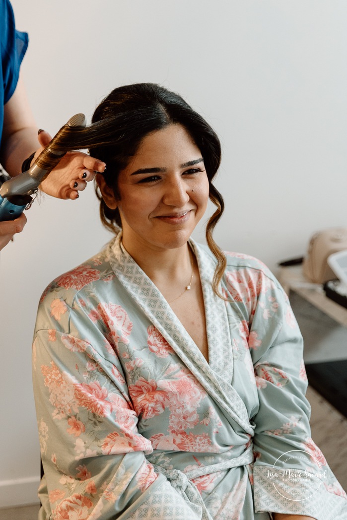 Bride getting ready with bridesmaids in hotel room. Mariage à l'Auberge des Îles au Lac-Saint-Jean. Photographe de mariage au Saguenay-Lac-Saint-Jean.