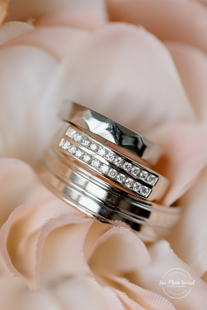 Wedding rings in flower bouquet. Bride getting ready with bridesmaids in hotel room. Mariage à l'Auberge des Îles au Lac-Saint-Jean. Photographe de mariage au Saguenay-Lac-Saint-Jean.