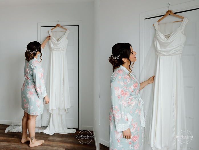 Bride looking at dress. Bride getting ready with bridesmaids in hotel room. Mariage à l'Auberge des Îles au Lac-Saint-Jean. Photographe de mariage au Saguenay-Lac-Saint-Jean.