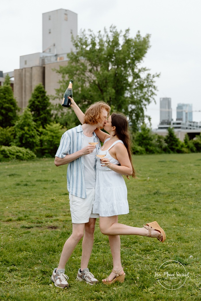 Champagne bottle engagement photos. Urban engagement photos. Séance photo de fiançailles à Montréal. Montreal engagement photos. Photographe de mariage à Montréal. Montreal wedding photographer. Séance photo Canal de Lachine. Lachine Canal photoshoot.