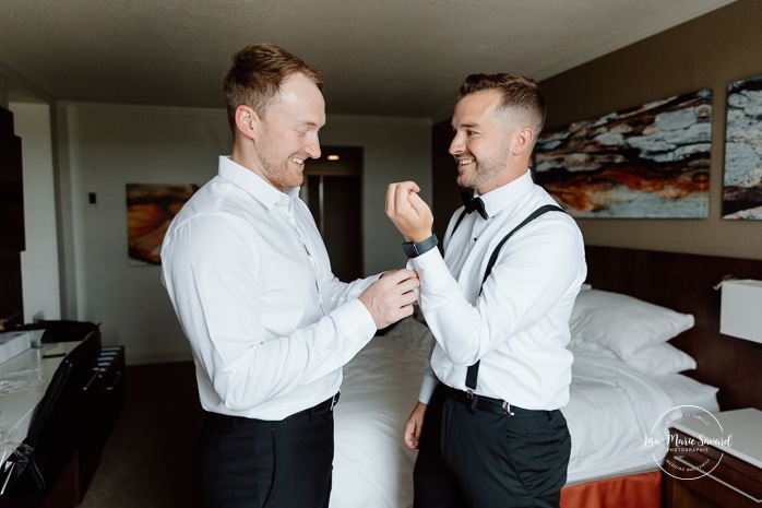 Groom getting ready with groomsmen in hotel room. Mariage à l'hôtel Delta Saguenay. Photographe mariage Saguenay-Lac-Saint-Jean