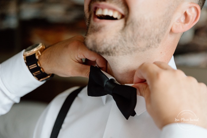 Groom getting ready with groomsmen in hotel room. Mariage à l'hôtel Delta Saguenay. Photographe mariage Saguenay-Lac-Saint-Jean