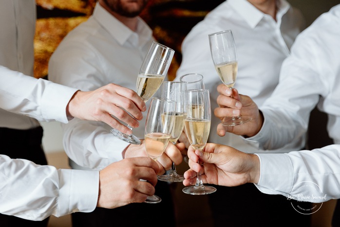 Groom getting ready with groomsmen in hotel room. Mariage à l'hôtel Delta Saguenay. Photographe mariage Saguenay-Lac-Saint-Jean