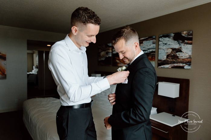 Groom getting ready with groomsmen in hotel room. Mariage à l'hôtel Delta Saguenay. Photographe mariage Saguenay-Lac-Saint-Jean