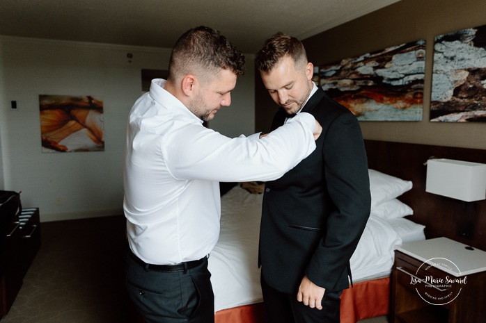 Groom getting ready with groomsmen in hotel room. Mariage à l'hôtel Delta Saguenay. Photographe mariage Saguenay-Lac-Saint-Jean