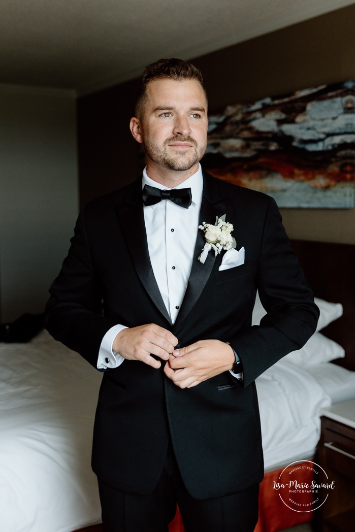 Groom getting ready with groomsmen in hotel room. Mariage à l'hôtel Delta Saguenay. Photographe mariage Saguenay-Lac-Saint-Jean