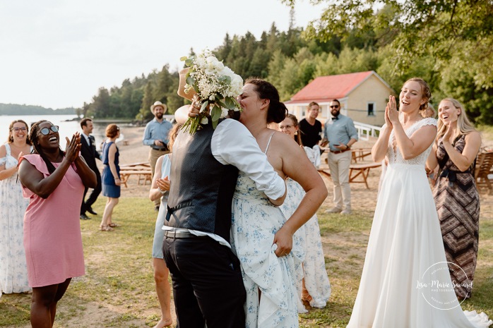 Bride throwing wedding bouquet. Mariage au bord du Lac-Saint-Jean. Auberge des Îles. Photographe mariage Saguenay-Lac-Saint-Jean