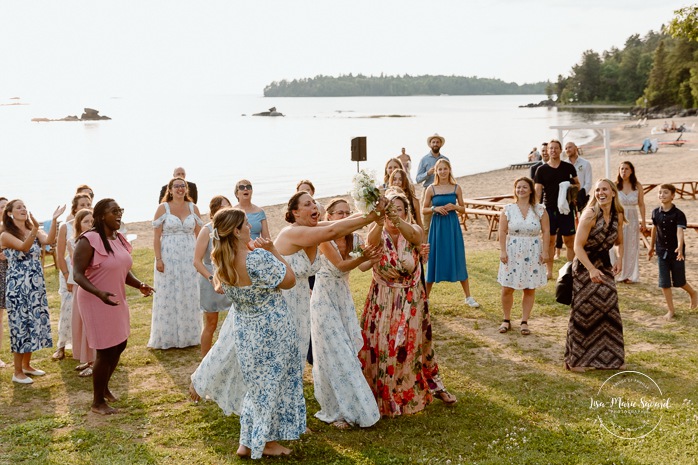 Bride throwing wedding bouquet. Mariage au bord du Lac-Saint-Jean. Auberge des Îles. Photographe mariage Saguenay-Lac-Saint-Jean