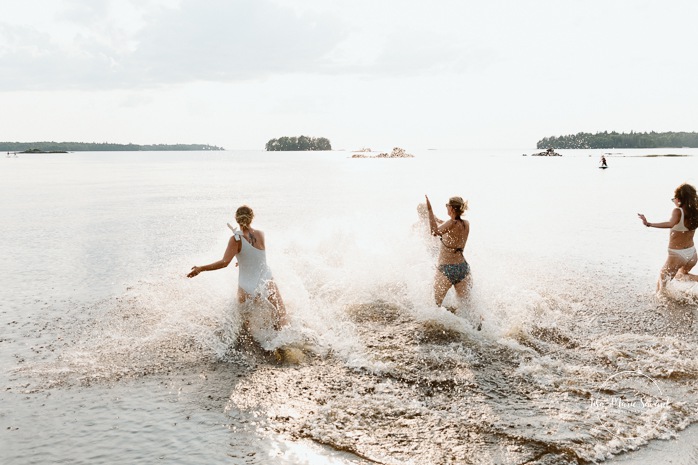 Bride swimming in lake to cool off. Mariage au bord du Lac-Saint-Jean. Auberge des Îles. Photographe mariage Saguenay-Lac-Saint-Jean