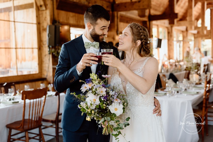 Bride and groom having a drink. Mariage à Le Pont Couvert de La Conception. Photographe mariage Laurentides. Le Pont Couvert wedding. Tremblant wedding photographer.