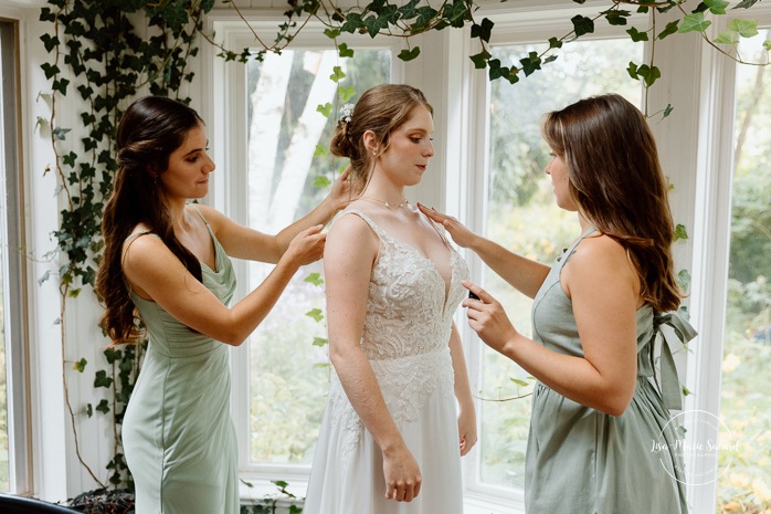 Bride getting ready with bridesmaids inside cabin. Mariage à Le Pont Couvert de La Conception. Photographe mariage Laurentides. Le Pont Couvert wedding. Tremblant wedding photographer.
