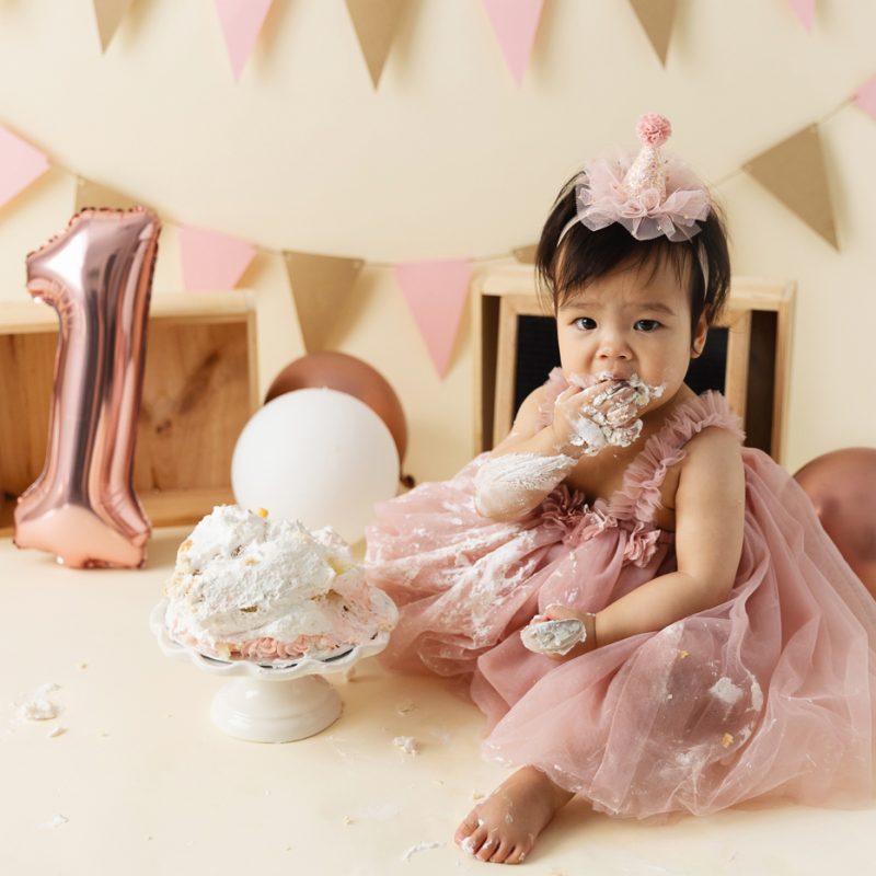 Minimalist girl Cake Smash photos. Cream and pink Cake Smash setup. Simple Smash the Cake photos. Photos de Cake Smash à Montréal. Photographe Cake Smash à Montréal. Montreal Cake Smash photoshoot. Montreal Cake Smash photographer.