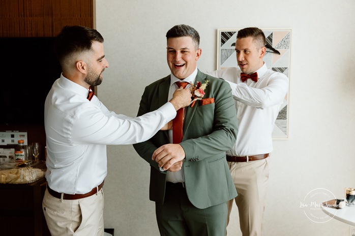 Groom getting ready with groomsmen in hotel room. Sheraton St-Hyacinthe. Mariage au Domaine St-Simon en automne. Photographe de mariage en Montérégie. Domaine St-Simon wedding.