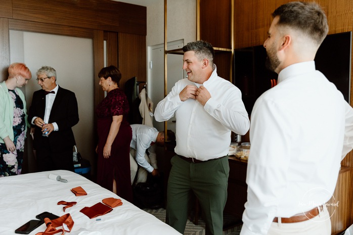 Groom getting ready with groomsmen in hotel room. Sheraton St-Hyacinthe. Mariage au Domaine St-Simon en automne. Photographe de mariage en Montérégie. Domaine St-Simon wedding.