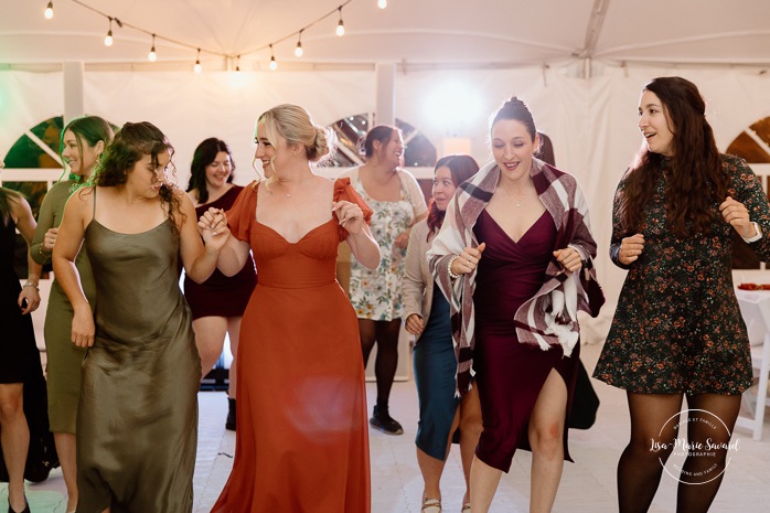Wedding guests having fun on the dancefloor. Wedding dancefloor photos. Outdoor tent wedding reception ideas. Mariage au Domaine St-Simon en automne. Photographe de mariage en Montérégie. Domaine St-Simon wedding.