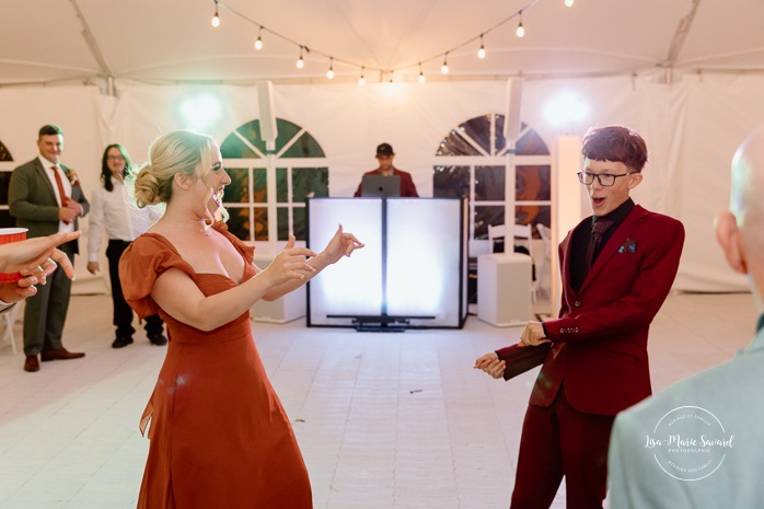 Wedding guests having fun on the dancefloor. Wedding dancefloor photos. Outdoor tent wedding reception ideas. Mariage au Domaine St-Simon en automne. Photographe de mariage en Montérégie. Domaine St-Simon wedding.