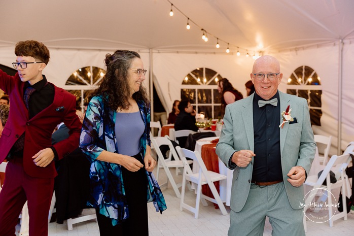 Wedding guests having fun on the dancefloor. Wedding dancefloor photos. Outdoor tent wedding reception ideas. Mariage au Domaine St-Simon en automne. Photographe de mariage en Montérégie. Domaine St-Simon wedding.