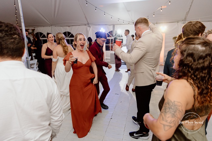 Wedding guests having fun on the dancefloor. Wedding dancefloor photos. Outdoor tent wedding reception ideas. Mariage au Domaine St-Simon en automne. Photographe de mariage en Montérégie. Domaine St-Simon wedding.
