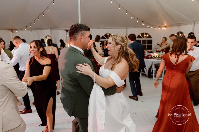 Wedding guests having fun on the dancefloor. Wedding dancefloor photos. Outdoor tent wedding reception ideas. Mariage au Domaine St-Simon en automne. Photographe de mariage en Montérégie. Domaine St-Simon wedding.