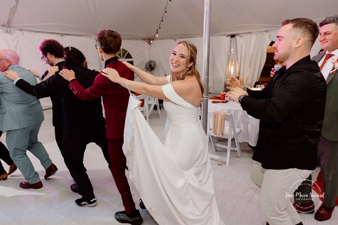 Wedding guests having fun on the dancefloor. Wedding dancefloor photos. Outdoor tent wedding reception ideas. Mariage au Domaine St-Simon en automne. Photographe de mariage en Montérégie. Domaine St-Simon wedding.