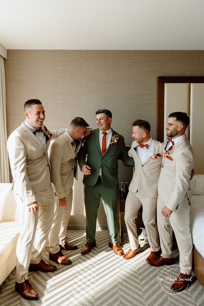 Groom getting ready with groomsmen in hotel room. Sheraton St-Hyacinthe. Mariage au Domaine St-Simon en automne. Photographe de mariage en Montérégie. Domaine St-Simon wedding.