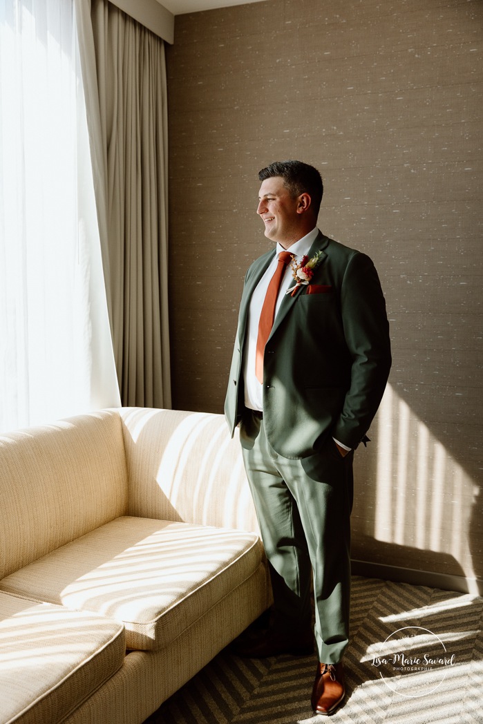 Groom getting ready with groomsmen in hotel room. Sheraton St-Hyacinthe. Mariage au Domaine St-Simon en automne. Photographe de mariage en Montérégie. Domaine St-Simon wedding.