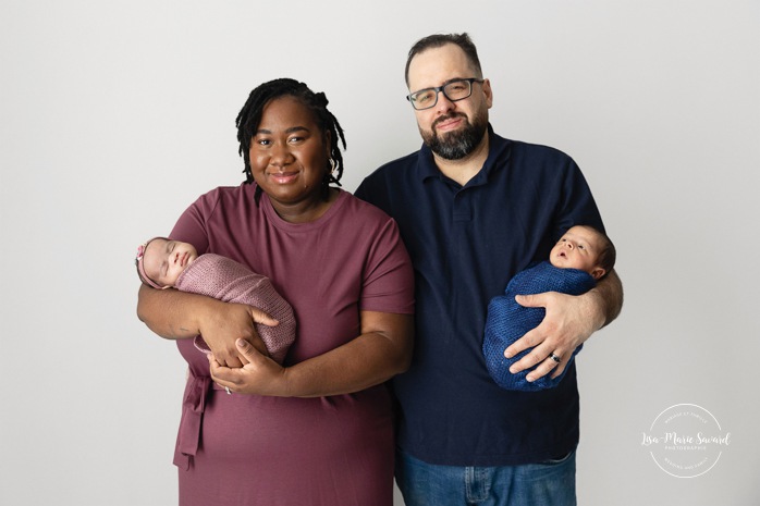 Twin newborn photos with parents. In-studio twin newborn photos. Minimalist newborn photos. Séance nouveau-né pour jumeaux à Montréal. Montreal twin newborn session. Photographe bébé Montréal. Montreal baby photographer.