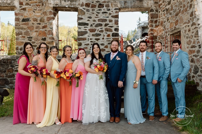Wedding party photos with five bridesmaids five groomsmen. Colorful wedding palette. Photographe de mariage au Saguenay. Photographe Saguenay-Lac-Saint-Jean. Mariage Pulperie de Chicoutimi. Jardin des Vestiges. Saguenay wedding photographer.