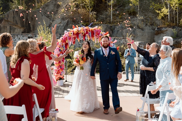 Outdoor wedding ceremony with floral arch. Colorful wedding ideas. Photographe de mariage au Saguenay. Photographe Saguenay-Lac-Saint-Jean. Mariage Pulperie de Chicoutimi. Jardin des Vestiges. Bâtiment 1912. Saguenay wedding photographer.