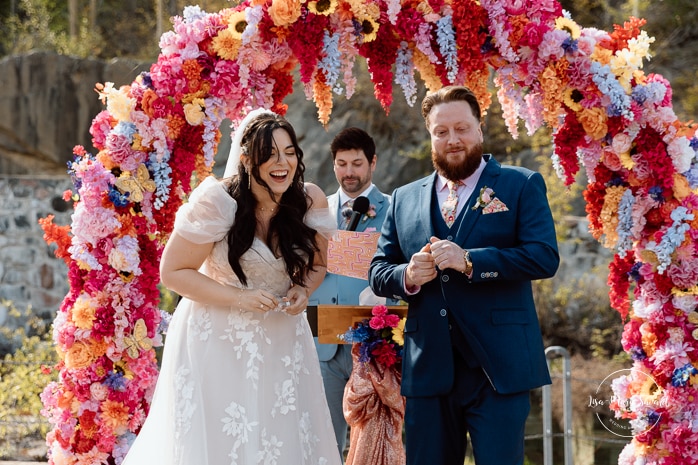 Outdoor wedding ceremony with floral arch. Colorful wedding ideas. Photographe de mariage au Saguenay. Photographe Saguenay-Lac-Saint-Jean. Mariage Pulperie de Chicoutimi. Jardin des Vestiges. Bâtiment 1912. Saguenay wedding photographer.