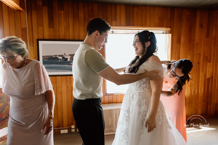Bride getting ready with bridesmaids inside conference room. Photographe de mariage au Saguenay. Photographe Saguenay-Lac-Saint-Jean. Auberge Le Parasol. Saguenay wedding photographer.